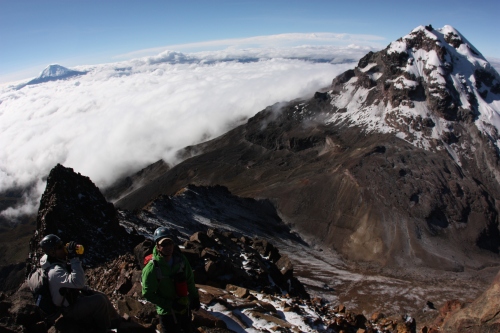Making the final push to the summit with Illiniza Norte and Cotopaxi in the background